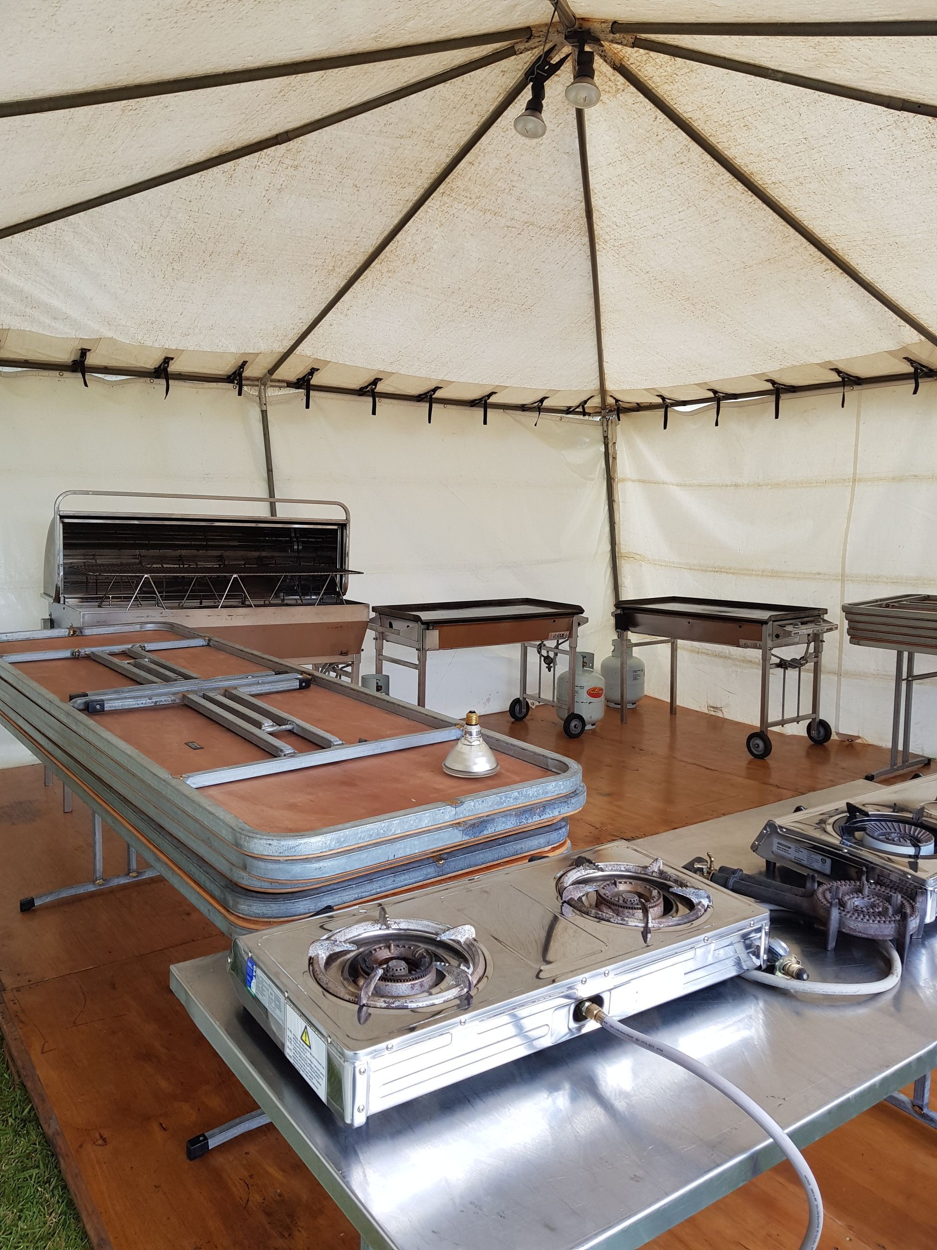 A stove is sitting on a table under a tent.