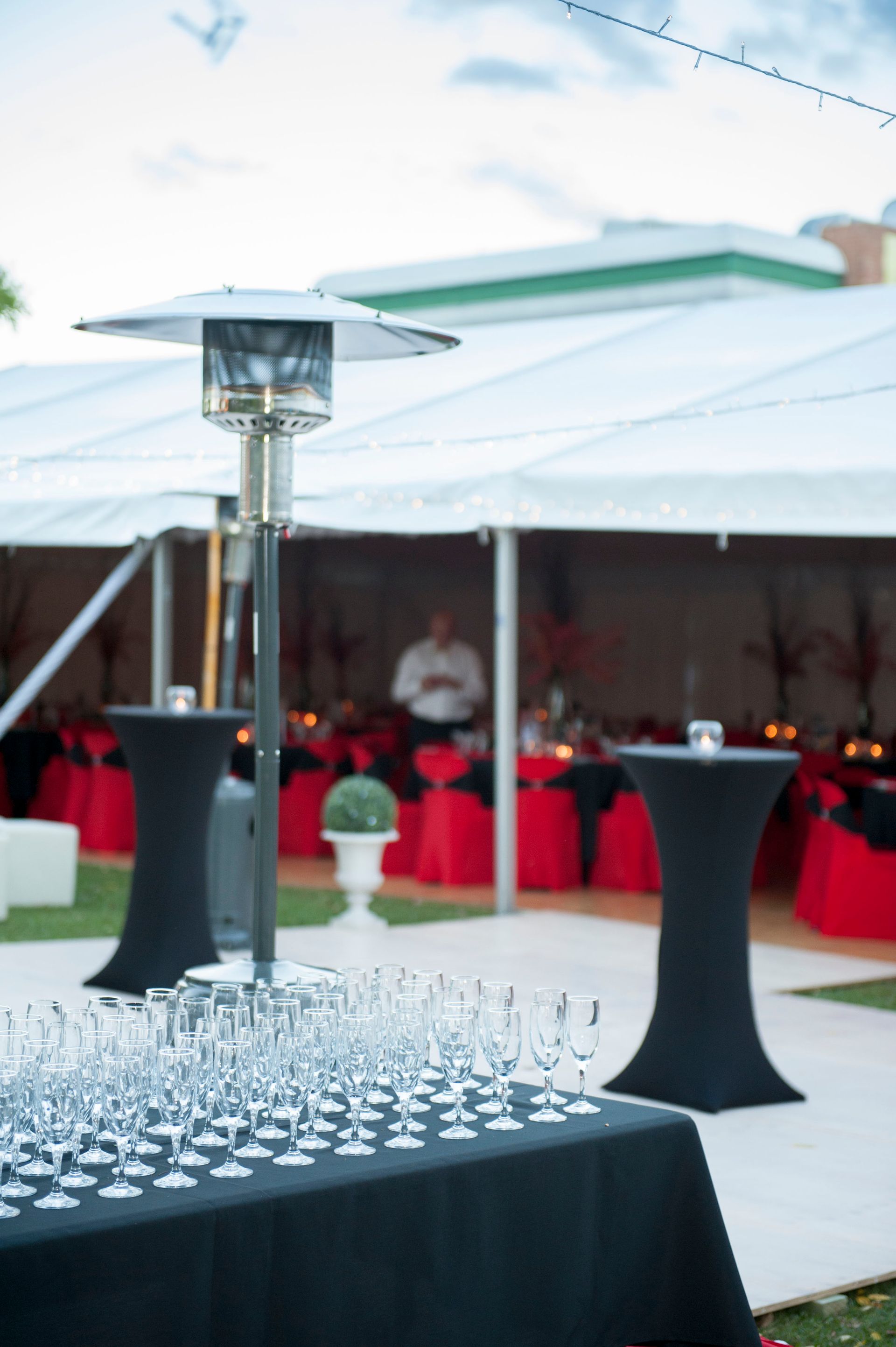 A bunch of wine glasses on a table under a tent