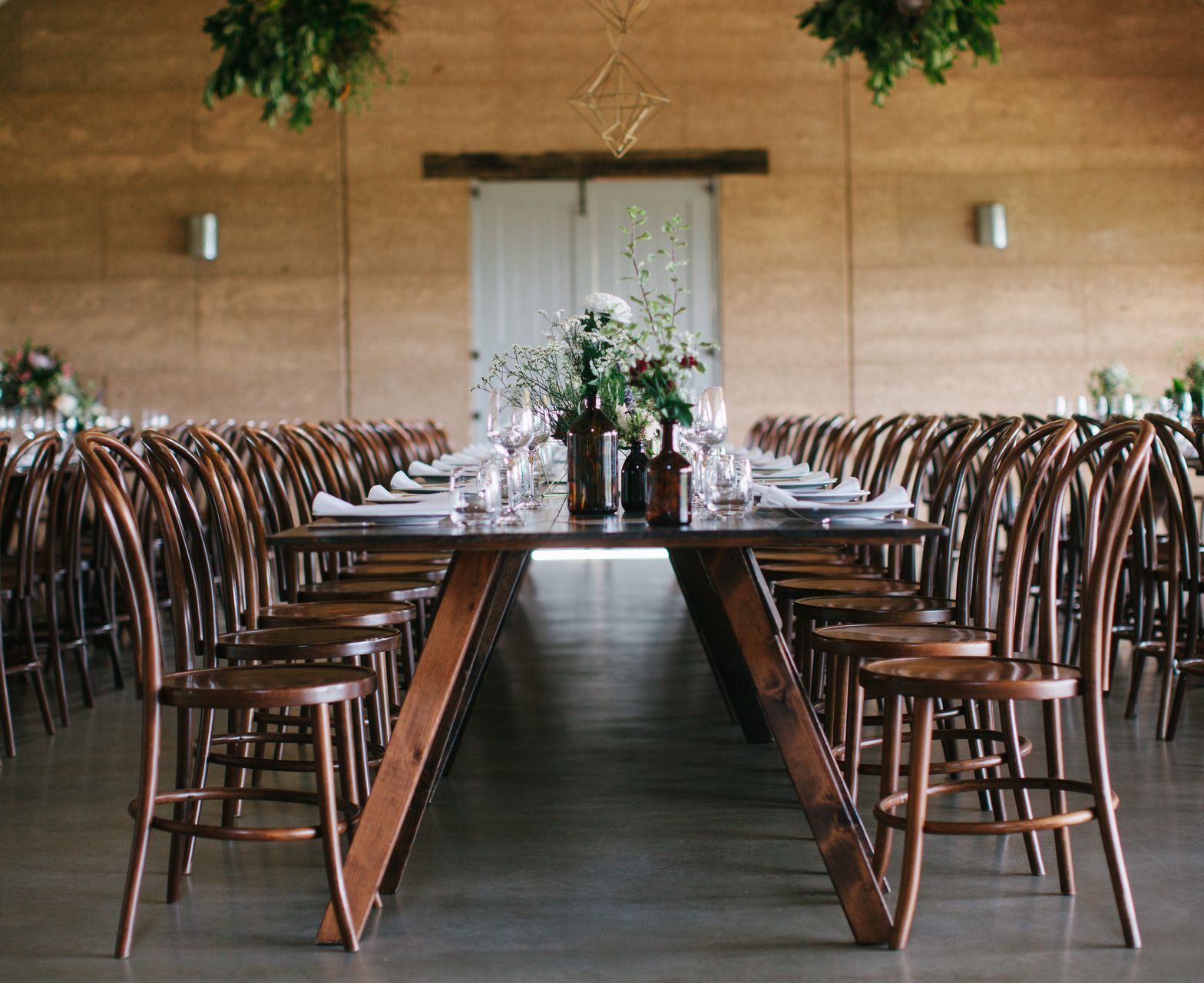 A long wooden table and chairs are lined up in a room.