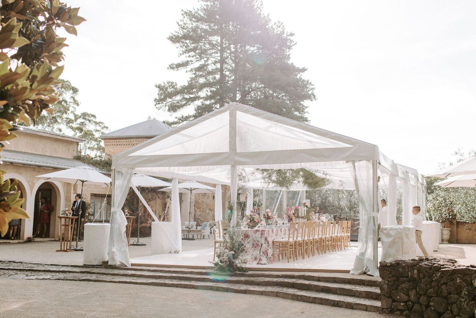 A large white tent is sitting in front of a building.