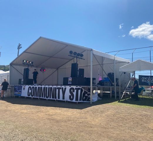 A large white tent with a sign that says community stage
