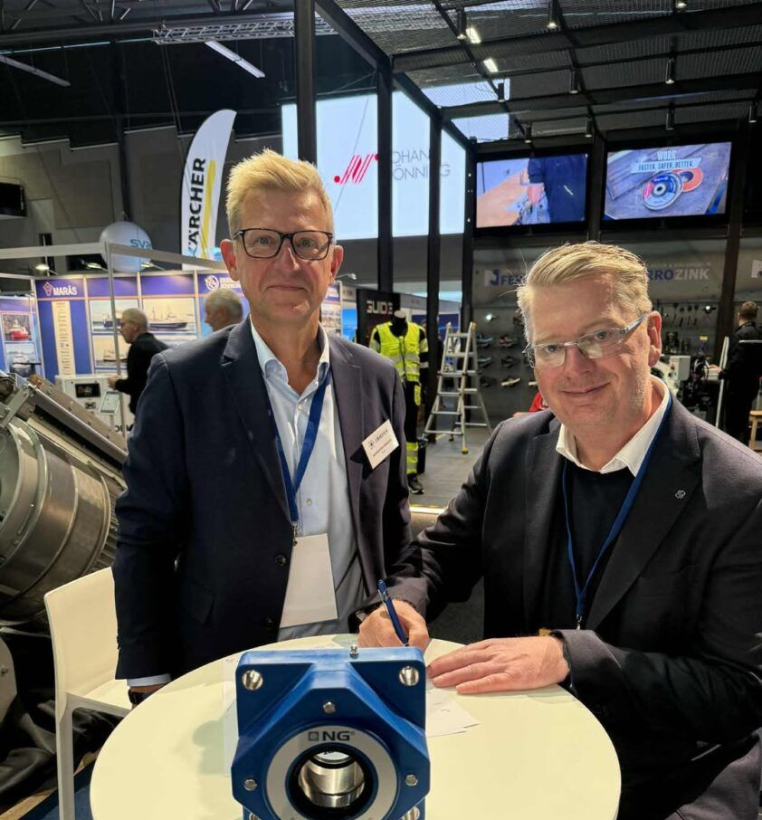 Tveir menn á sýningarbás að skoða bláa legu.