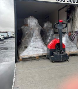 Brettajakkur inni í vörubíl fullum af innpökkuðum búnaði.