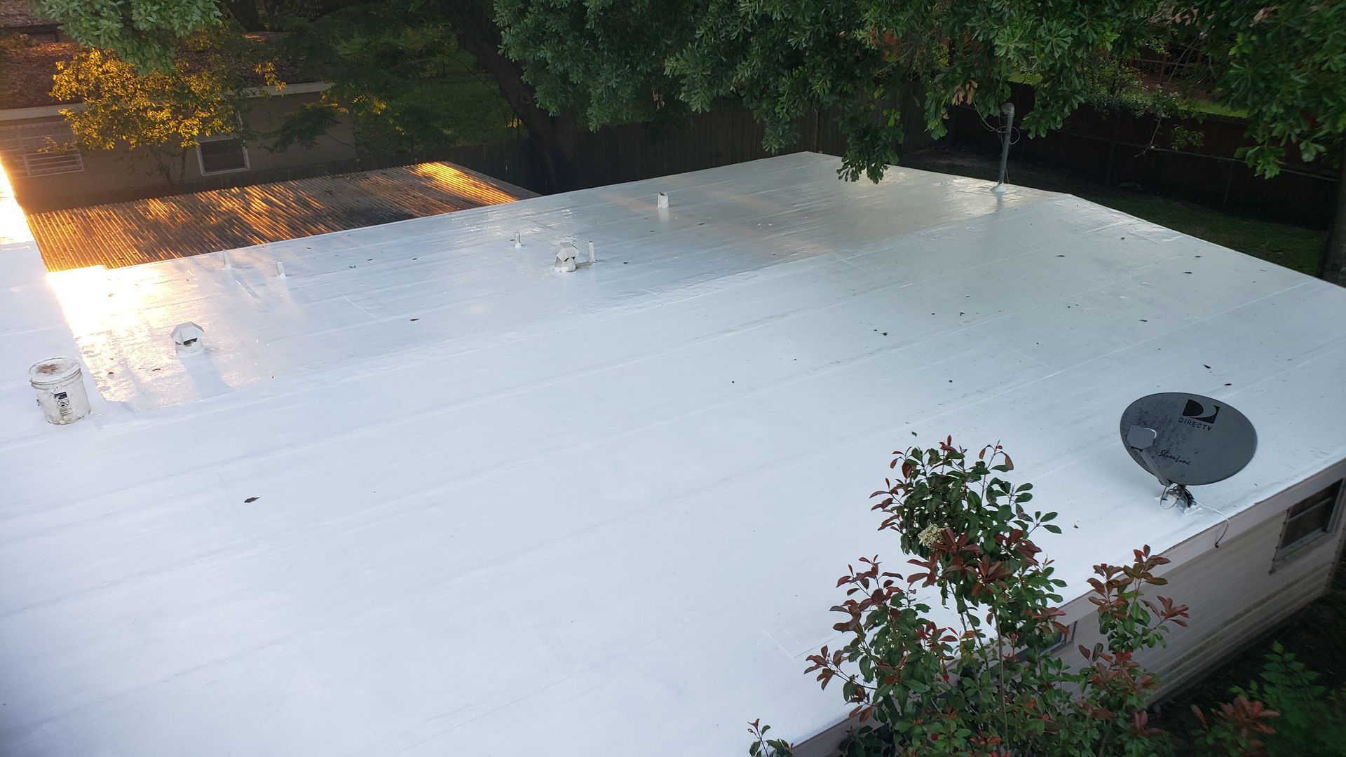 A white roof with a satellite dish on top of it.