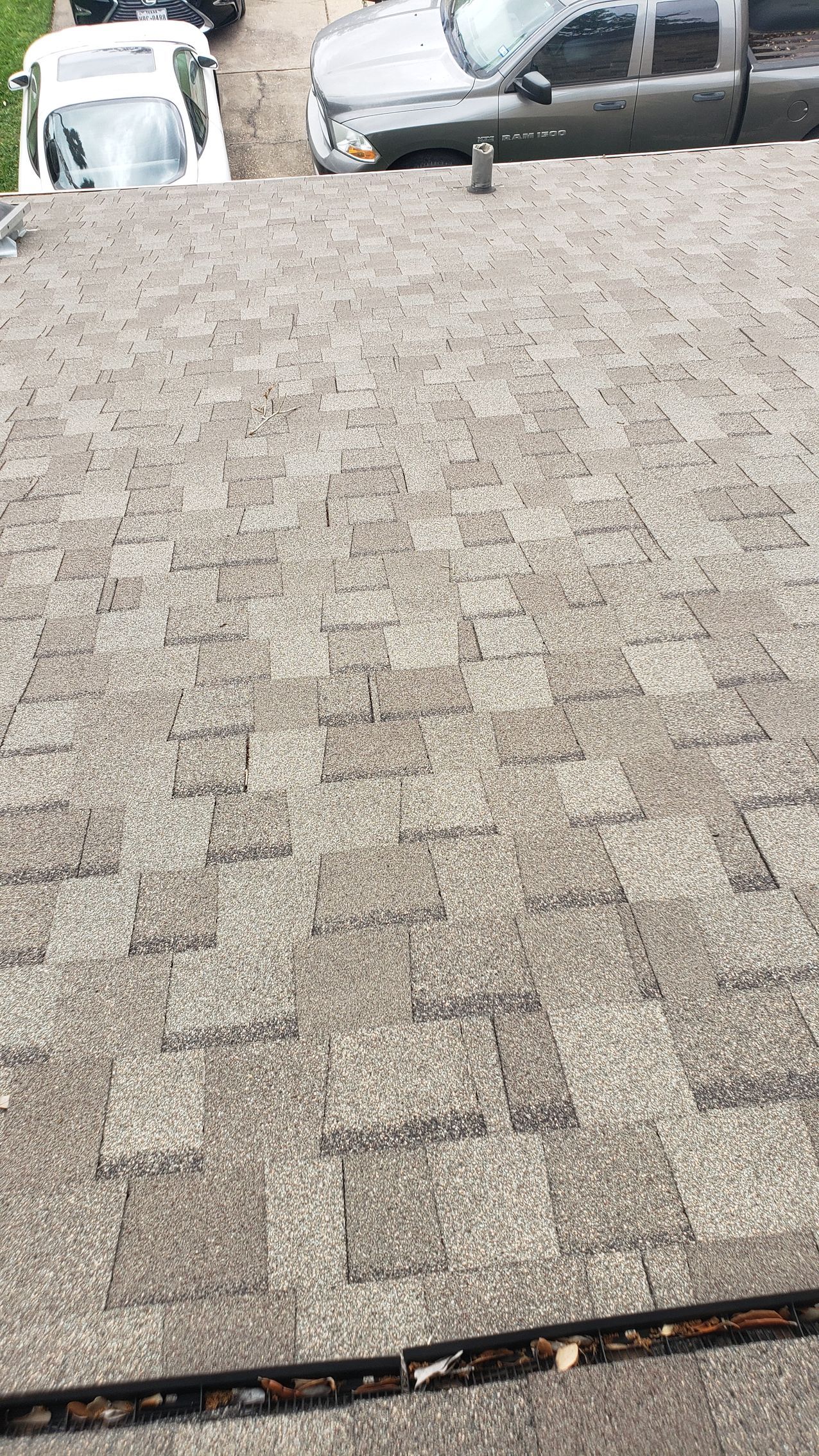 A close up of a roof with cars parked on it.