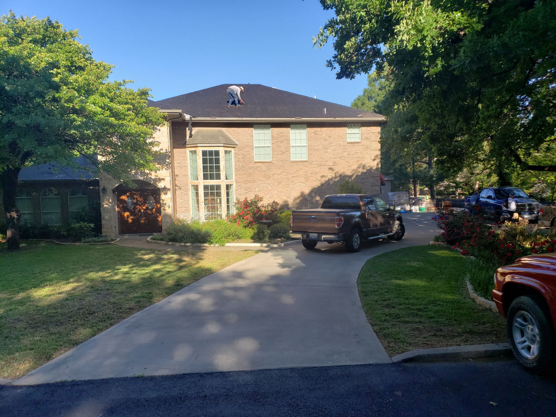 A truck is parked in front of a large brick house.