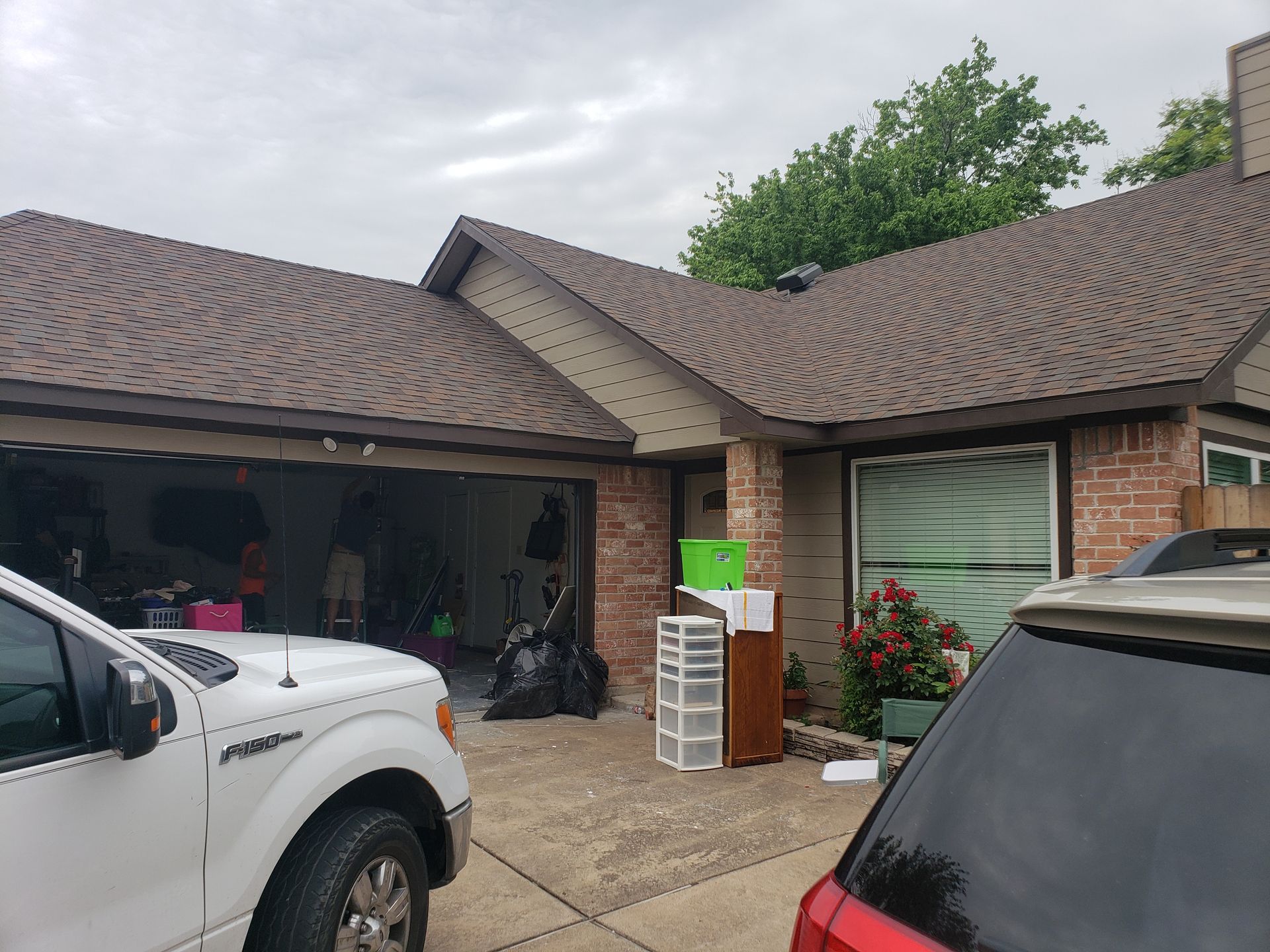 A white truck is parked in front of a brick house.