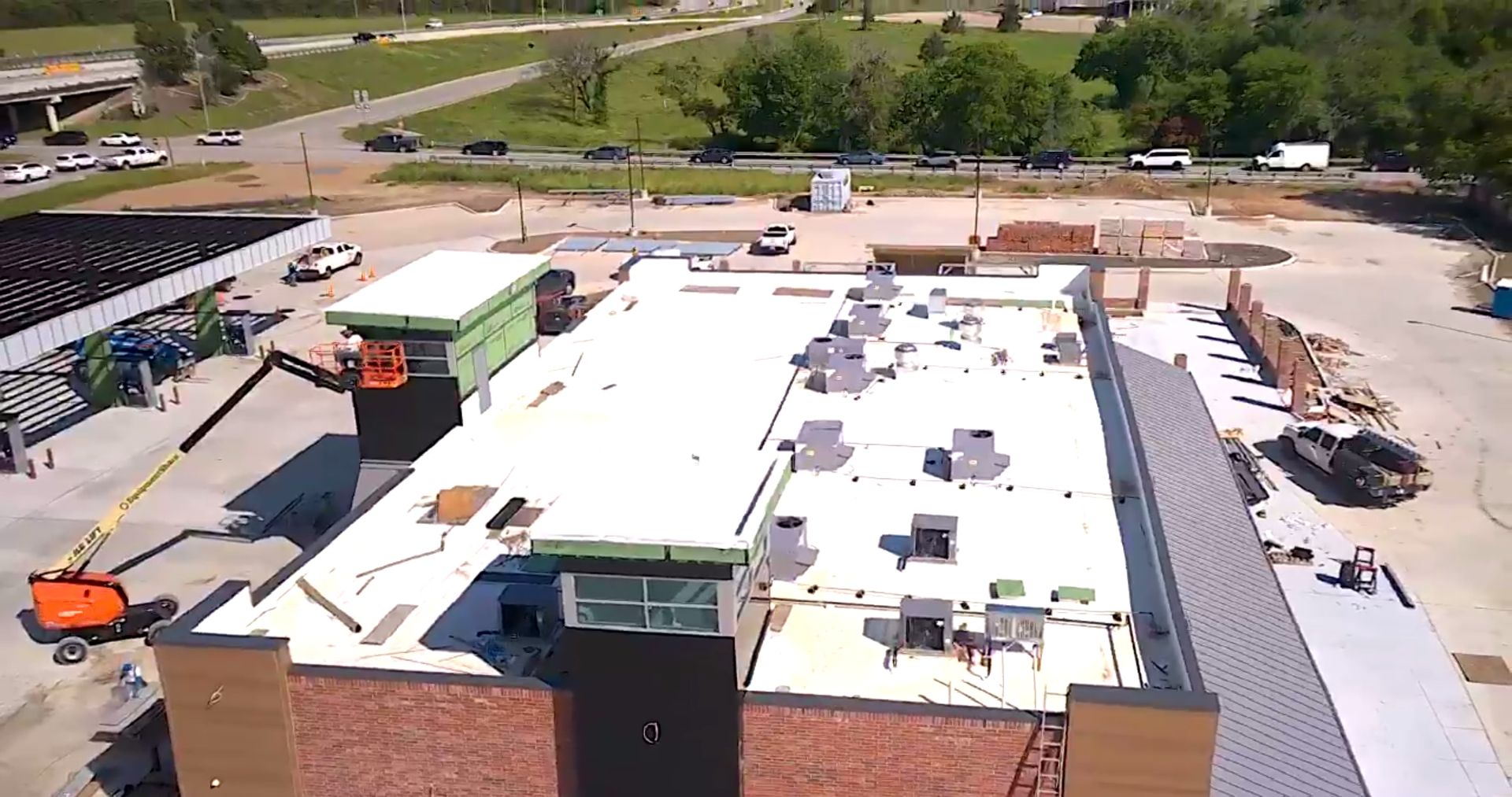An aerial view of a building under construction with a white roof.