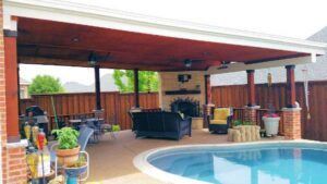 Covered outdoor patio with a pool, fireplace, and seating.