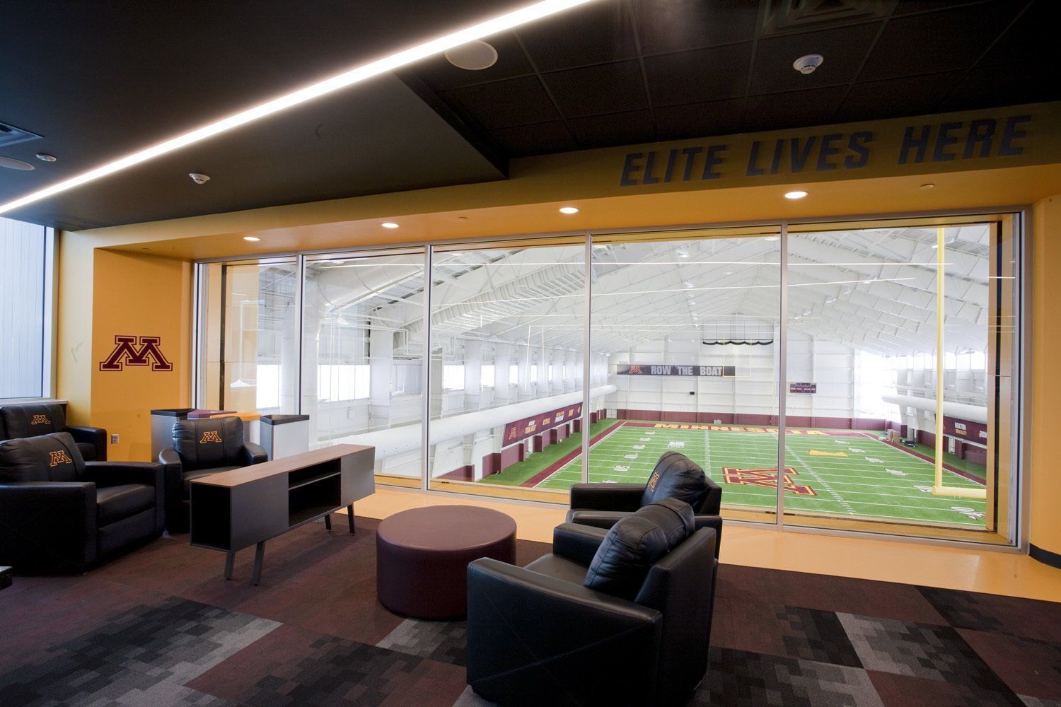 A living room with a view of a football field and a sign that says elite lives here