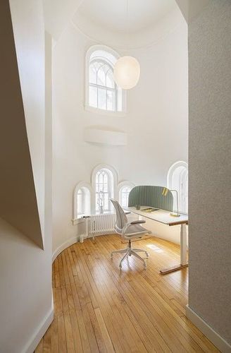 A Small Office With a Desk and Chair in a Hallway