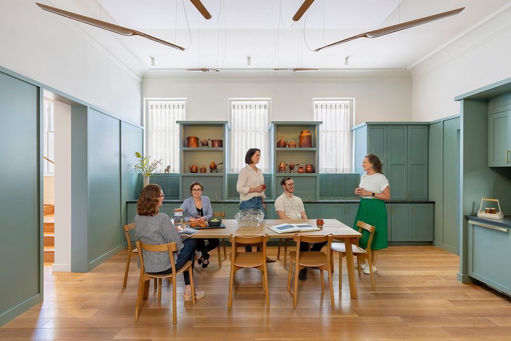 A group of people are sitting around a table in a room.