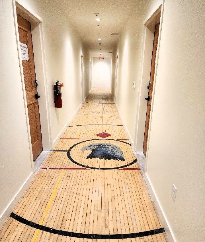 A long hallway with a picture of an eagle on the floor
