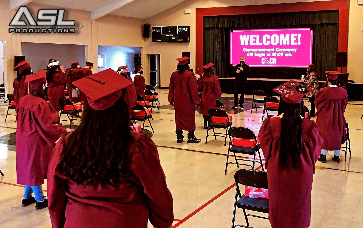 a group of graduates are standing in front of a welcome sign
