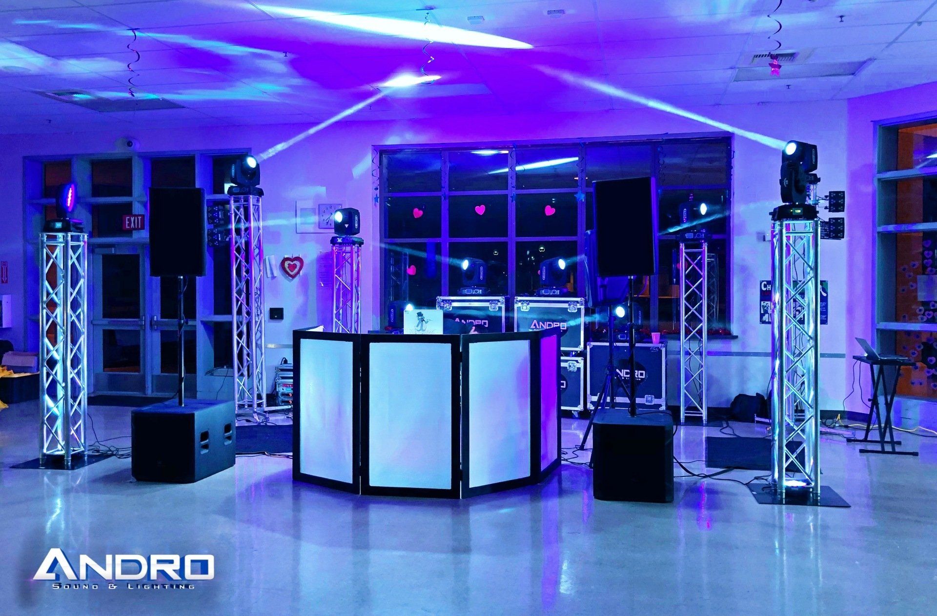 a dj booth in a room with purple lights and the word andro on the bottom