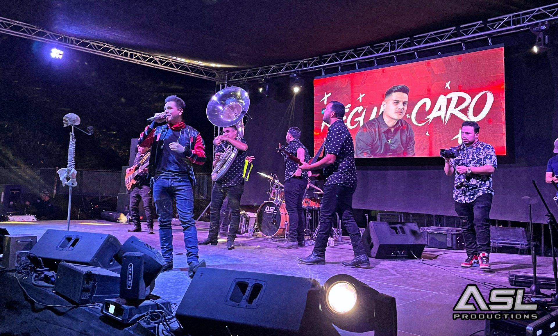 a group of people are standing on a stage in front of a large screen .