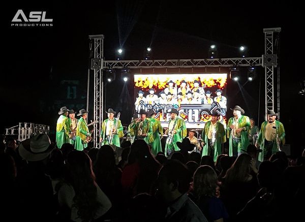 a group of people are standing on a stage in front of a large screen .