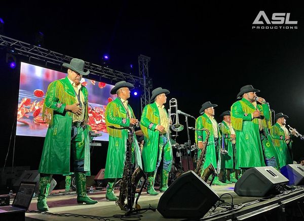 a group of men in green coats and cowboy hats are standing on a stage .