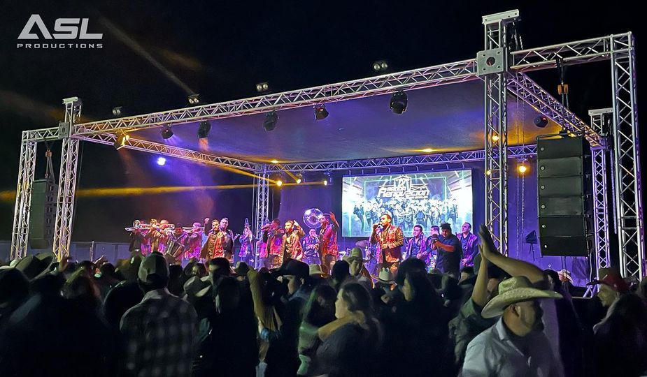 a large crowd of people are watching a band on stage .