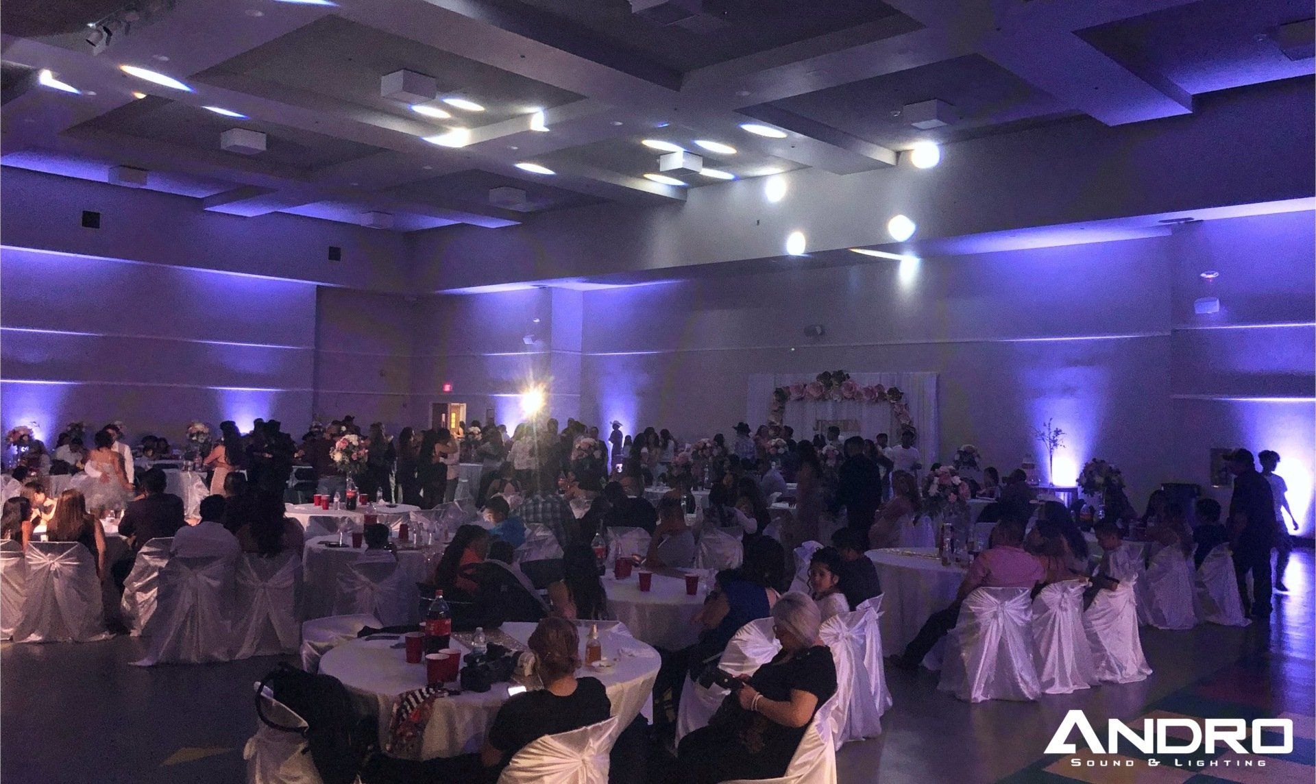 a large room filled with people sitting at tables and chairs .