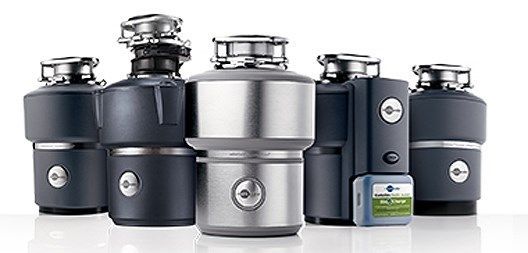 A group of garbage disposals are lined up next to each other on a white surface.