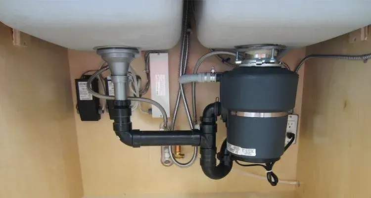 A kitchen sink with a garbage disposal underneath it.