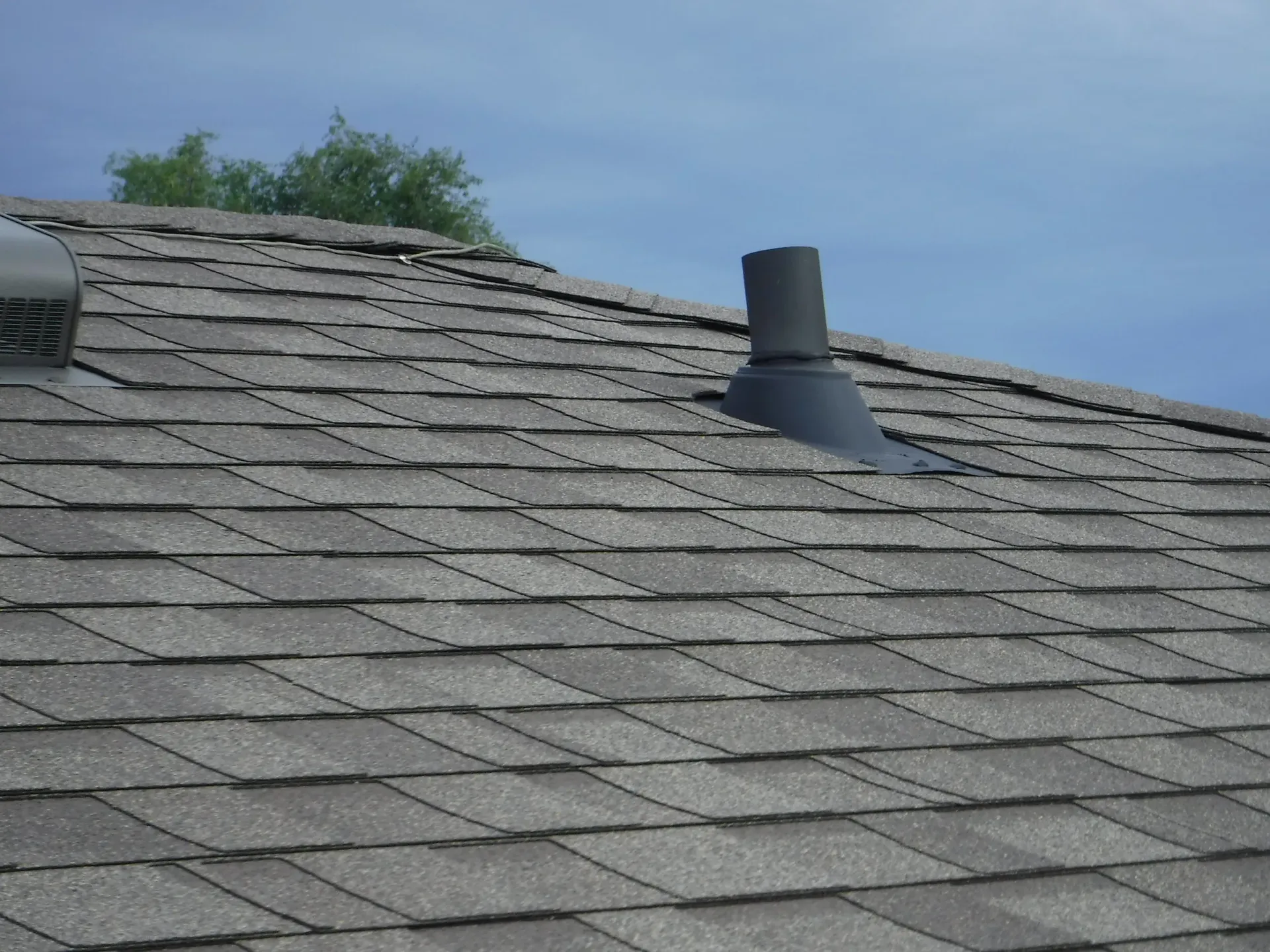 A roof with shingles and a chimney on it