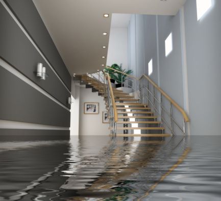A flooded hallway with stairs and a reflection of the stairs in the water