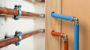 A couple of pipes hanging on a wall next to each other.