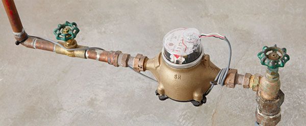 A close up of a water meter on a pipe.