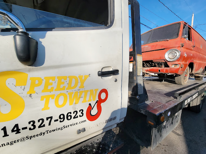A speedy towing truck with a red van on the back