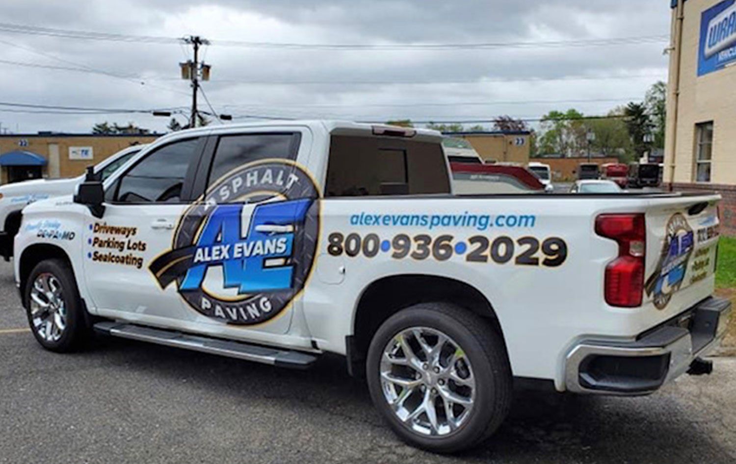 A white truck is parked in front of a building.