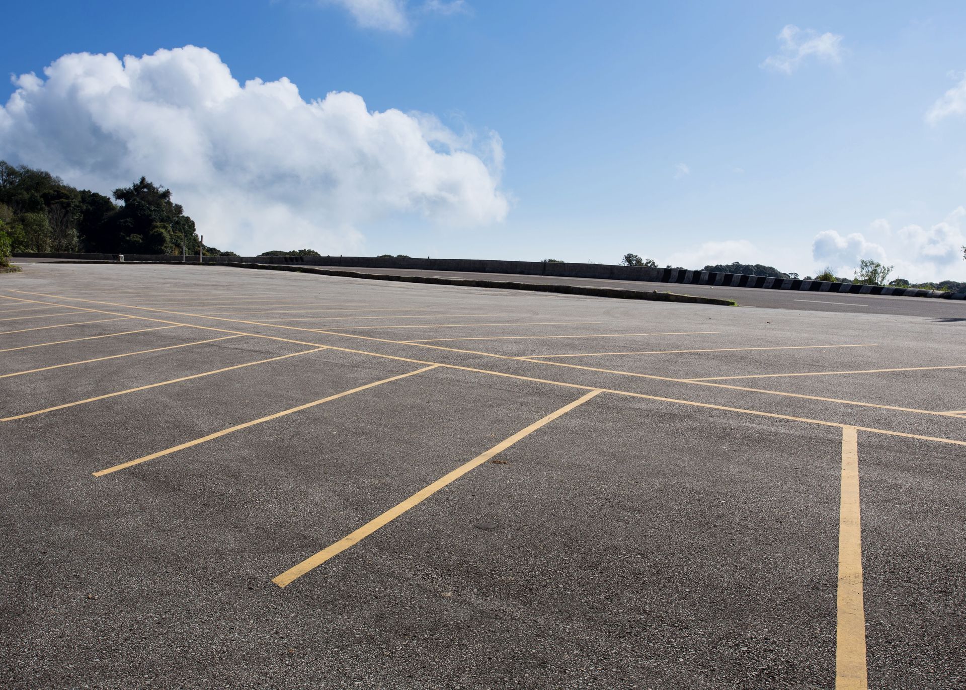 An empty parking lot with a blue sky in the background