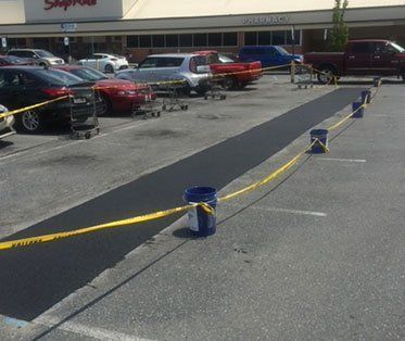 A parking lot with cars parked in front of a store.