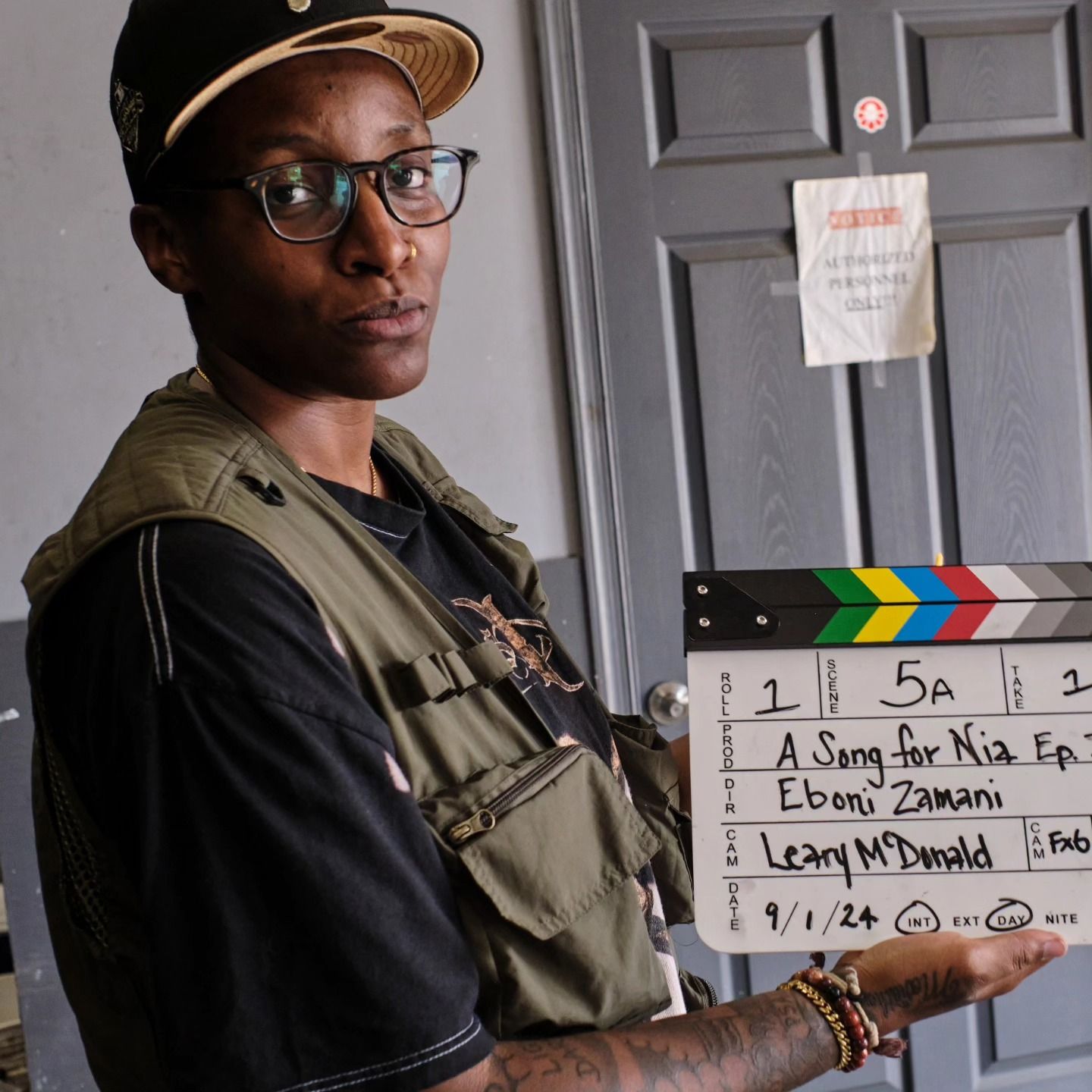A man holding a clapper board with the number 5a on it