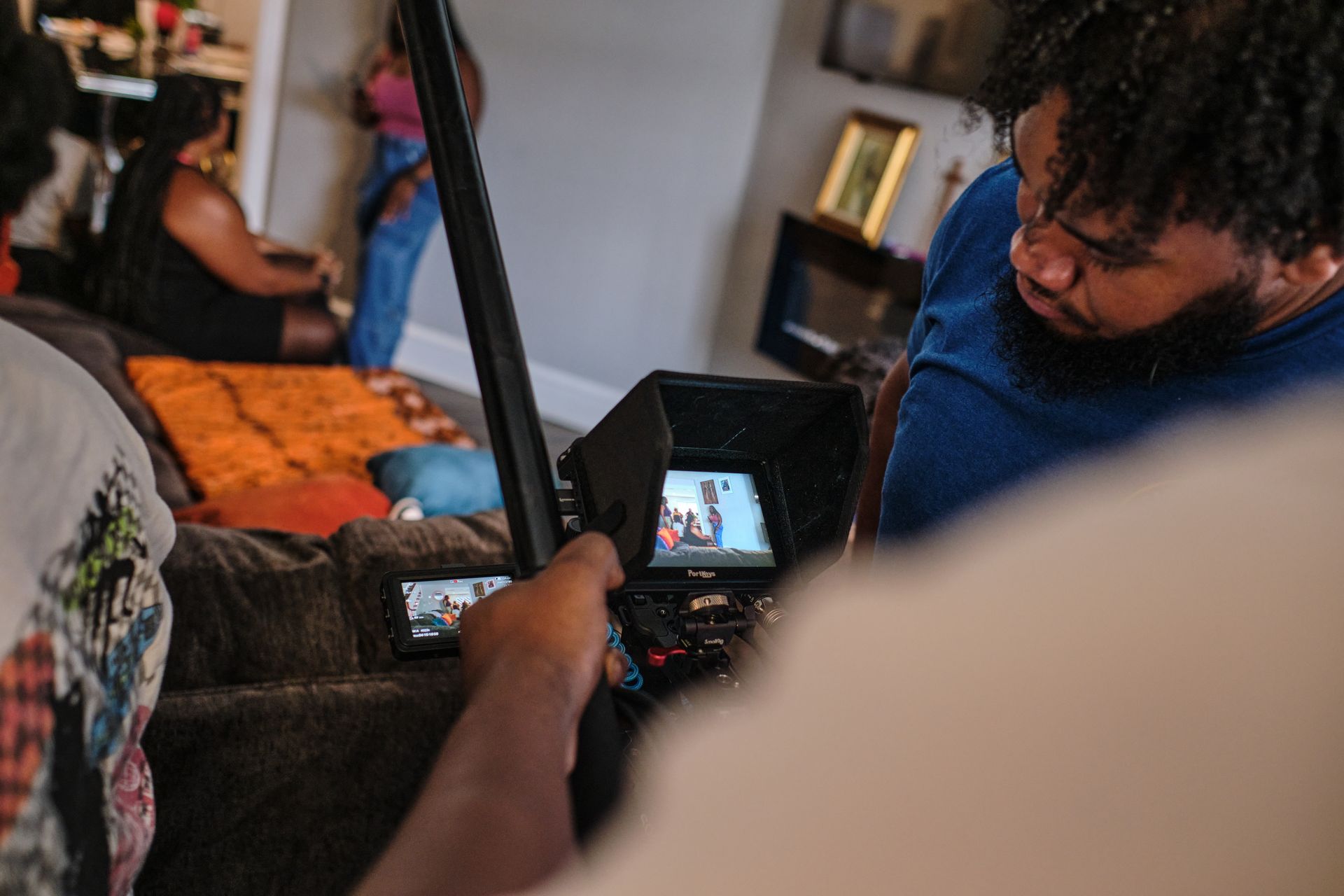 A group of people are sitting at tables in a room with a camera.