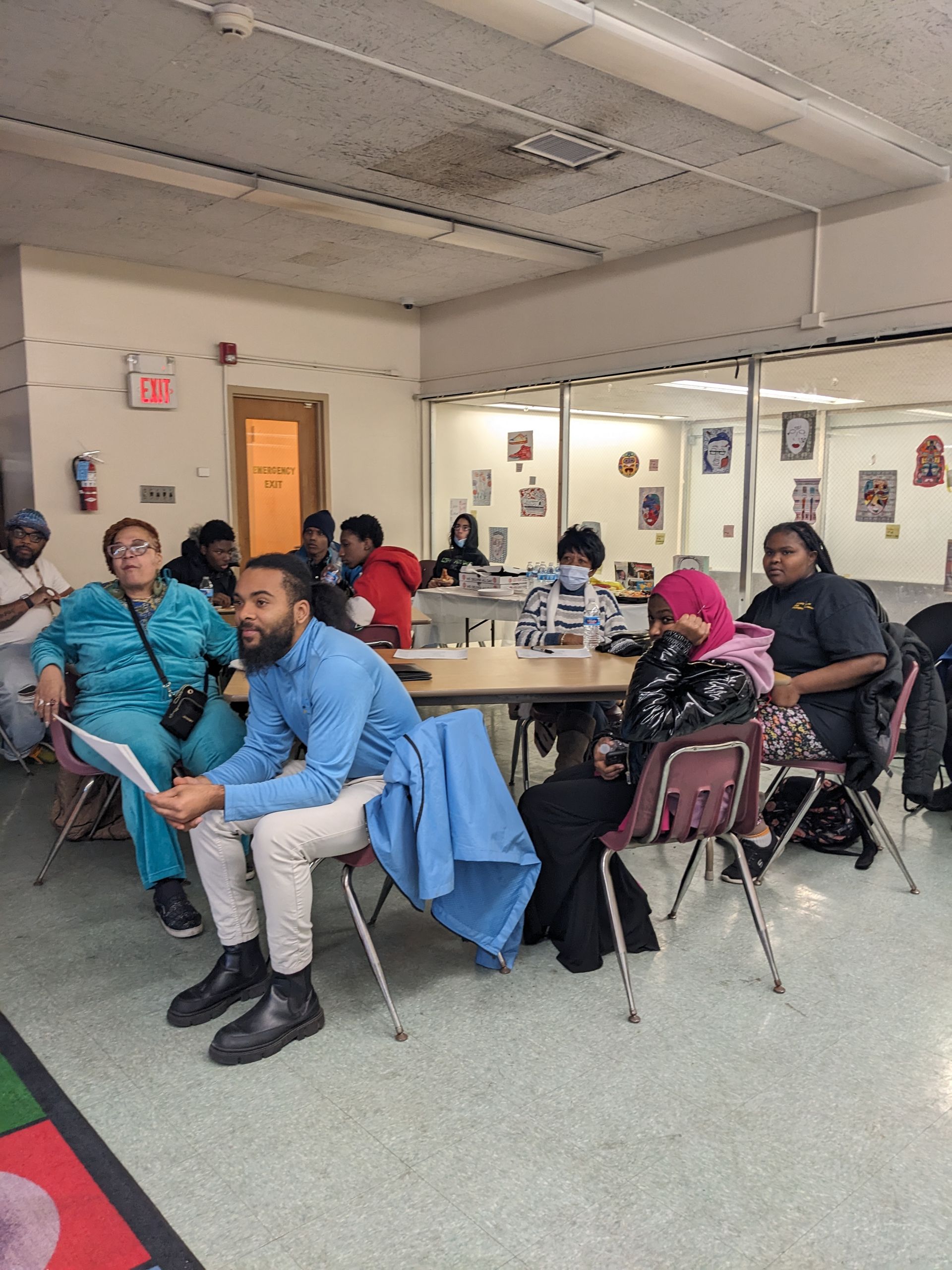 A man wearing headphones is sitting at a desk using a computer.