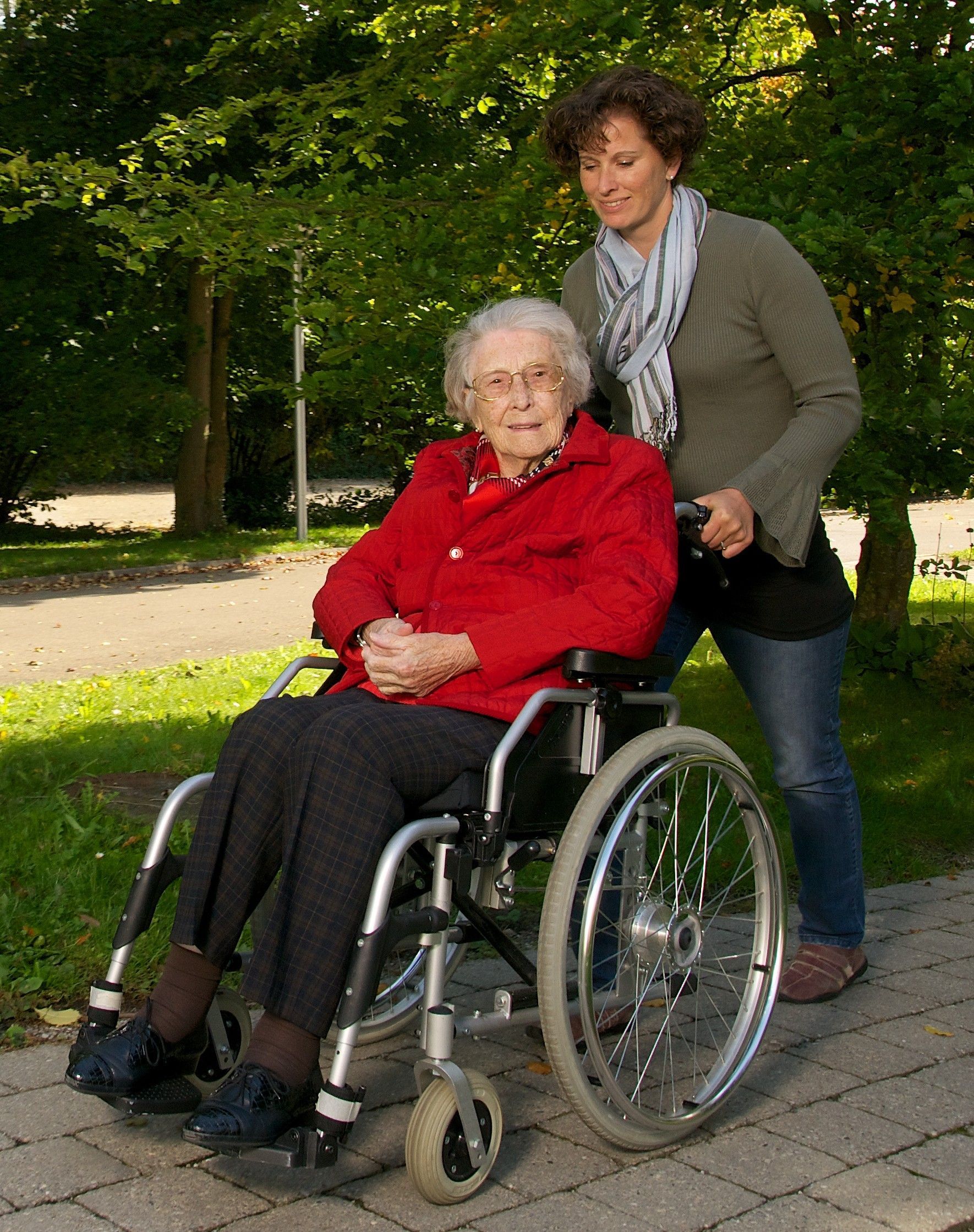 Seniorin im Rollstuhl mit Bereuerin