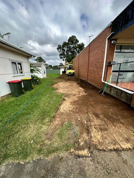 A Dirt Road Is Being Built In Front Of A Brick Building — About Time Plumbing & Civil Construction in Goulburn, NSW