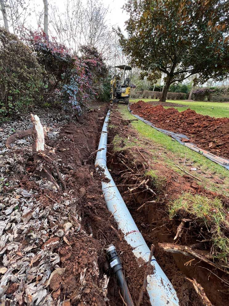 Laying Down Pipe Using Excavator — About Time Plumbing & Civil Construction in Moss Vale, NSW