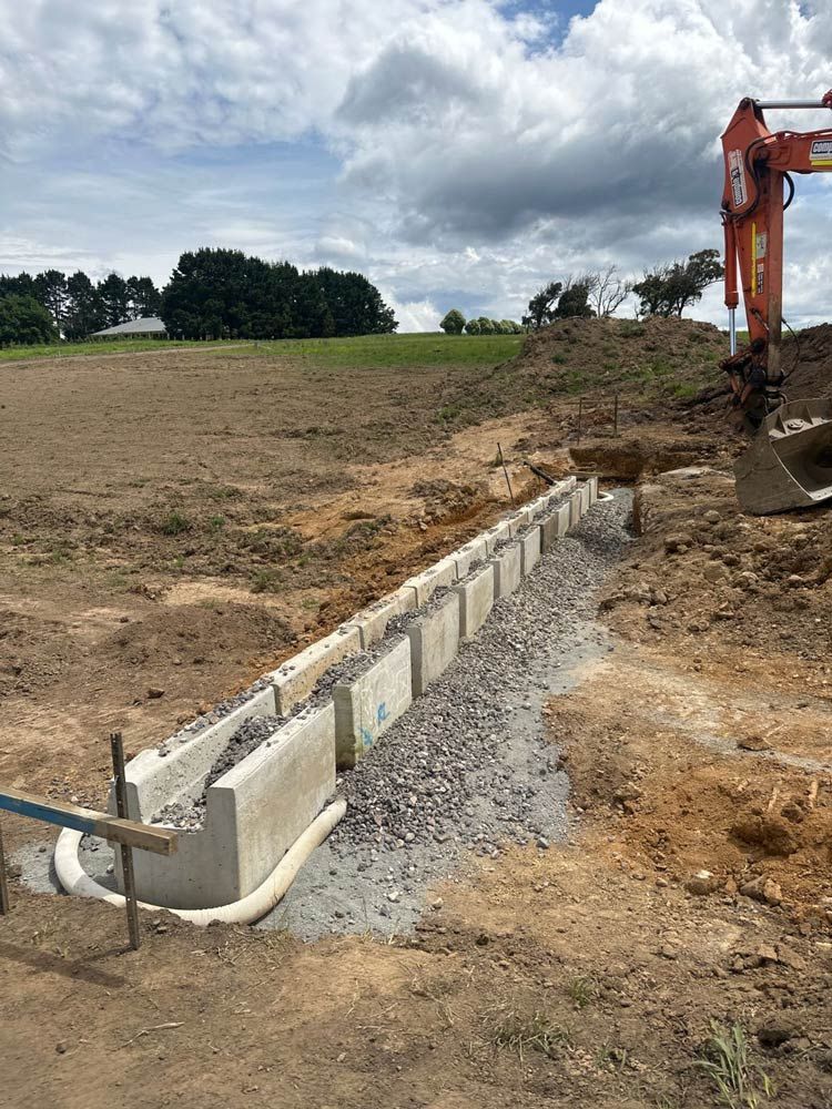 A Construction Site With A Large Excavator In The Background — About Time Plumbing & Civil Construction in Moss Vale, NSW