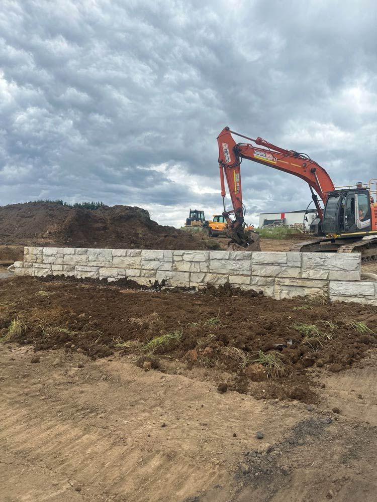 A Large Excavator Is Working On A Construction Site — About Time Plumbing & Civil Construction in Moss Vale, NSW