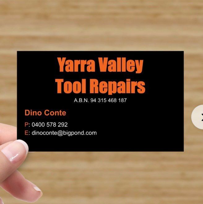 Business card for Yarra Valley Tool Repairs. Black card with orange text held by a hand.