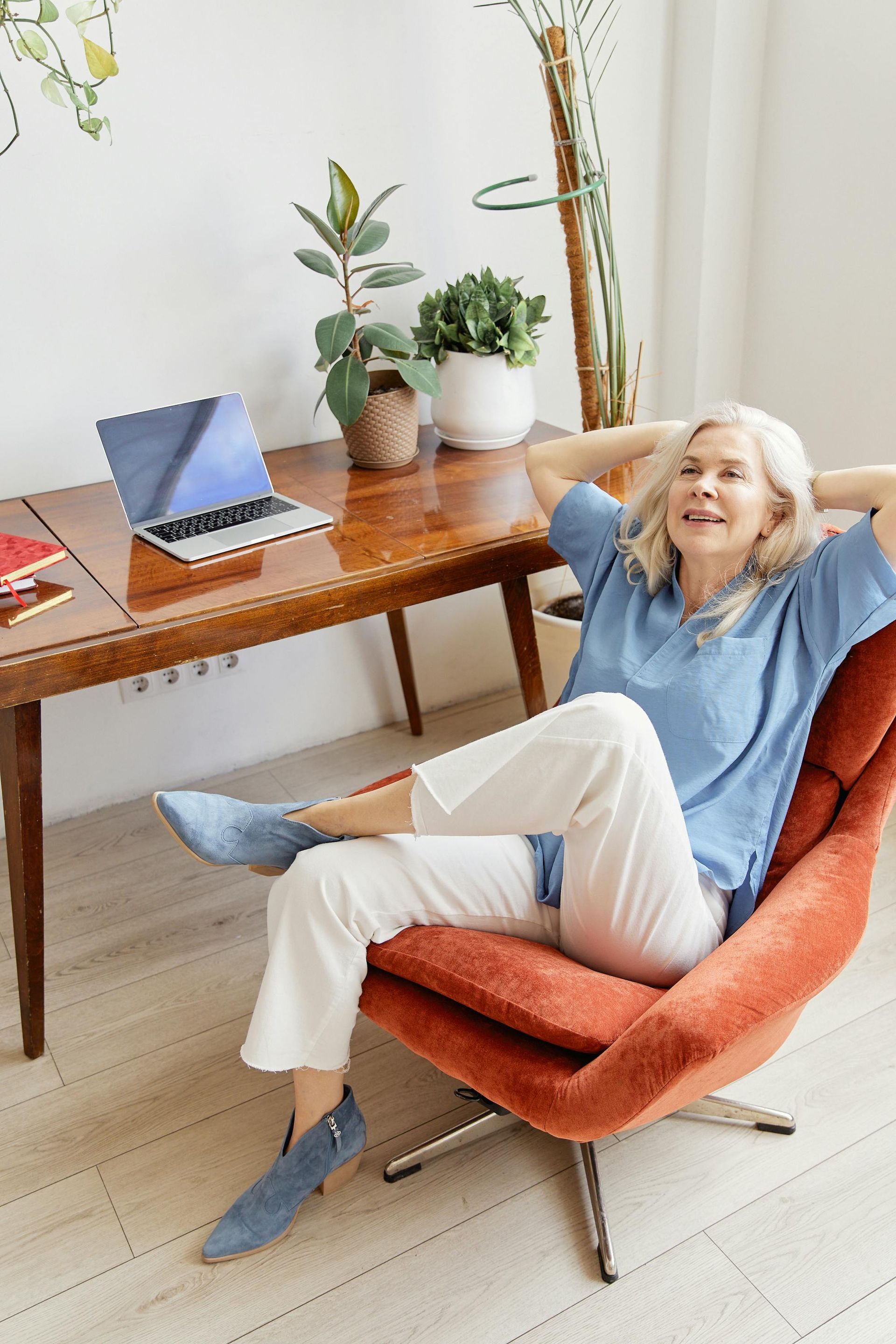 An image of an older woman relaxing in her desk chair.