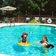 A woman and a child are playing in a swimming pool.