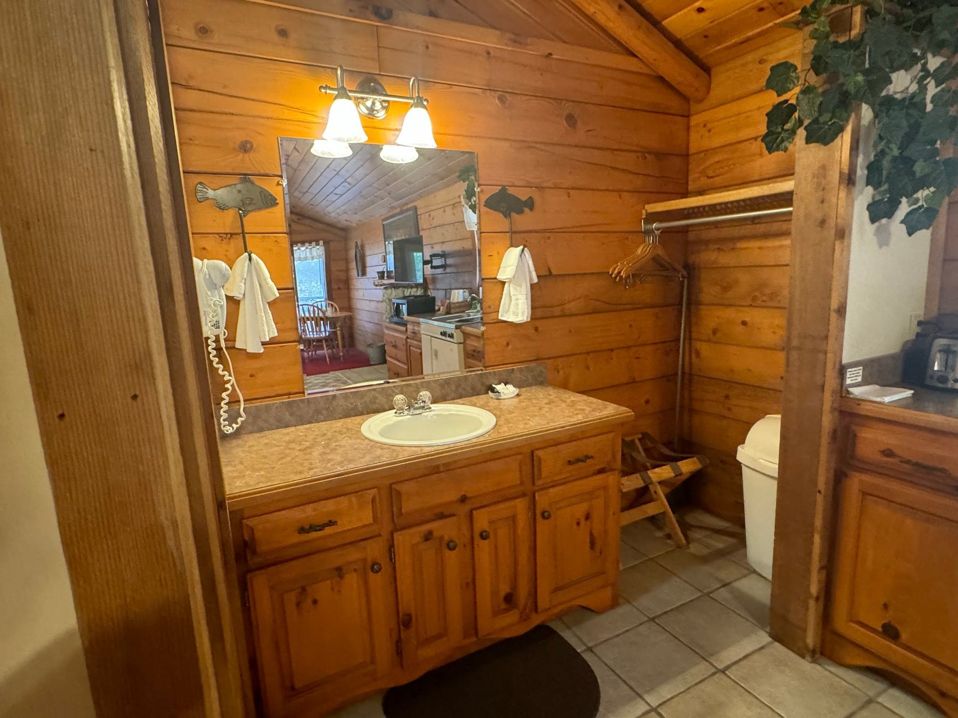 A bathroom in a log cabin with a sink and a large mirror.