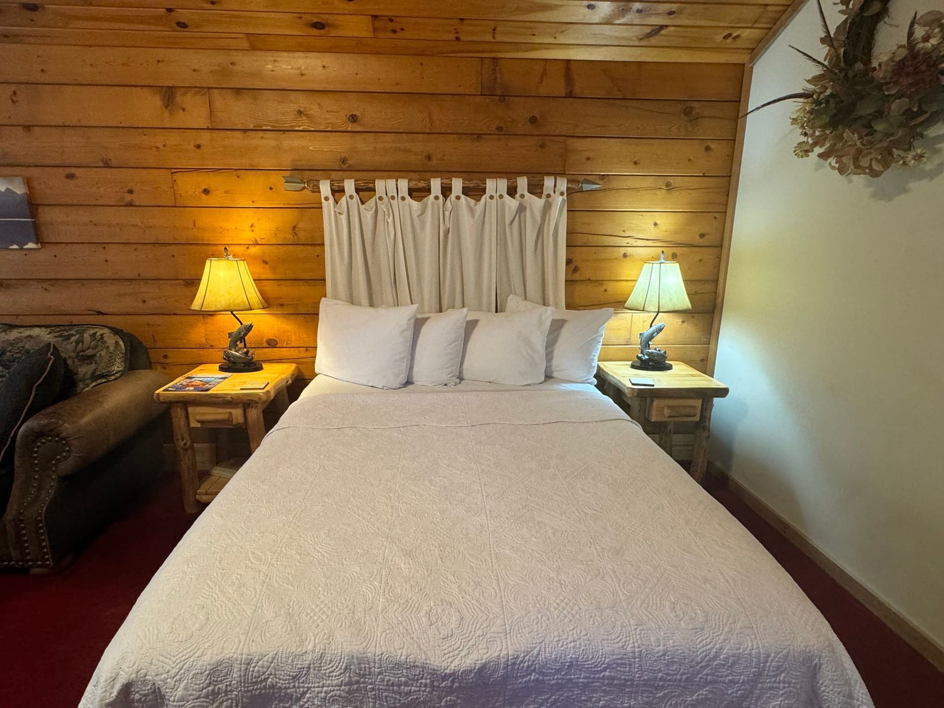 A bedroom with a bed lamps and a couch