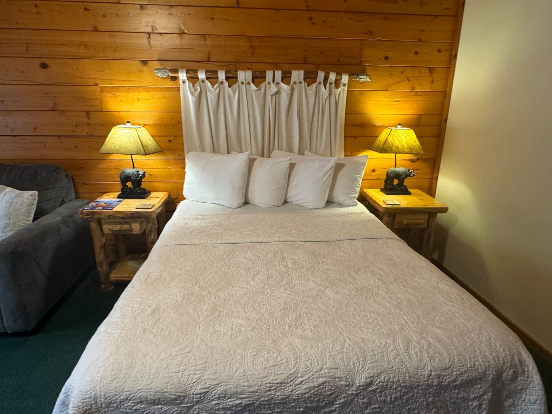 A bedroom with a bed and two lamps