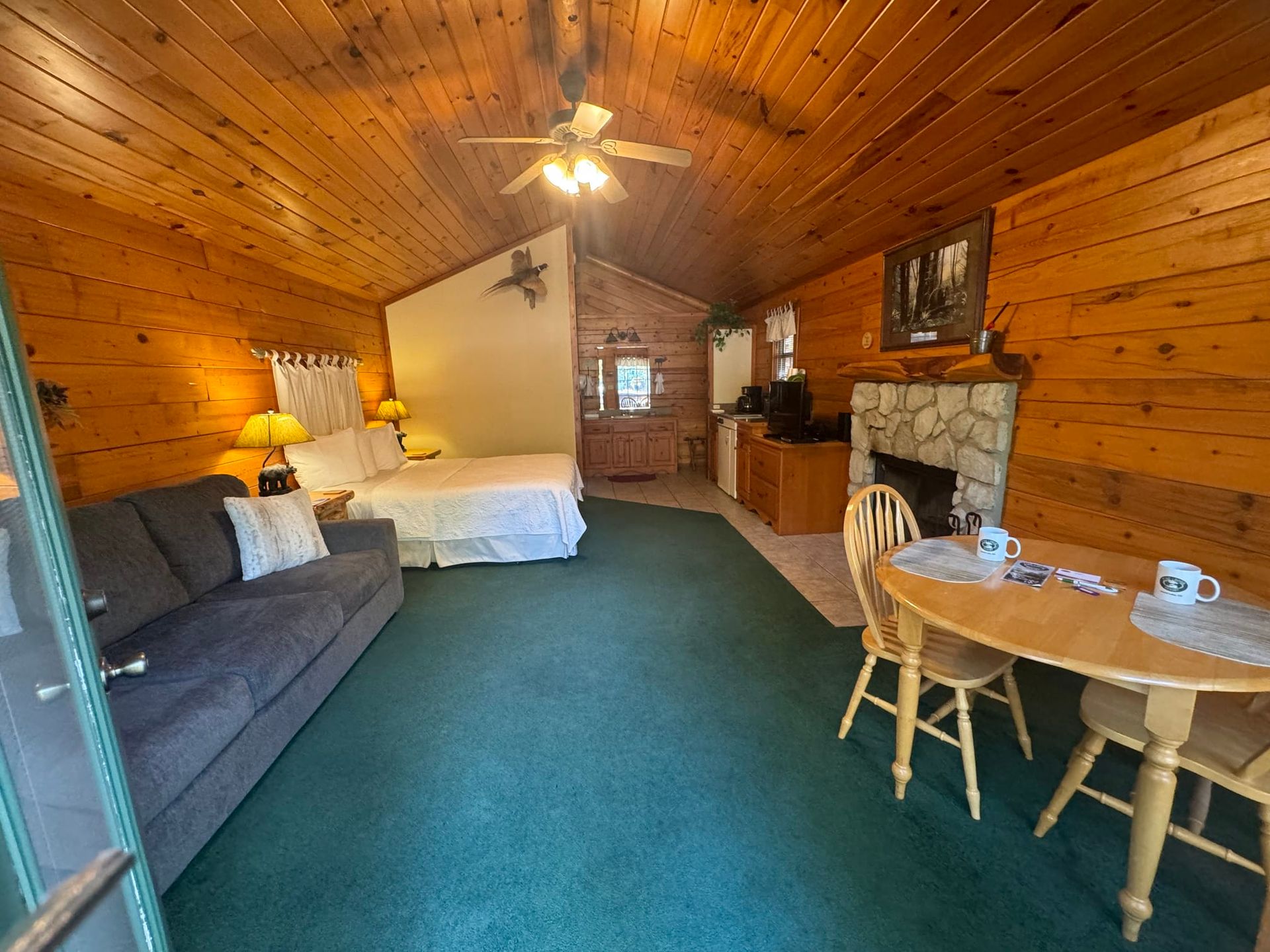 A living room with a couch , table , chairs and a bed.
