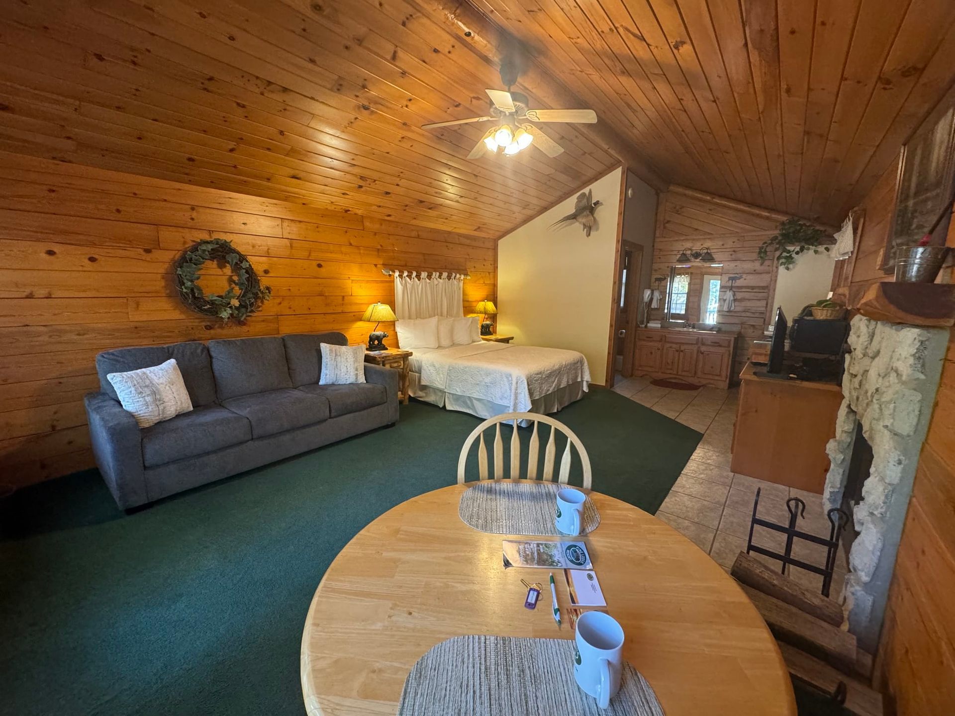 A living room with a couch , table , chairs and a bed.